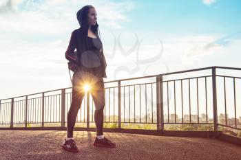 A woman in sportswear on evening city background