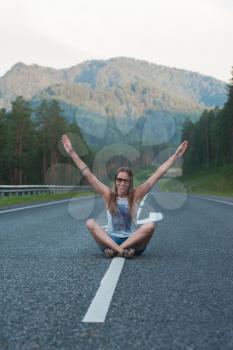 Woman sitting on the beauty road in mountain