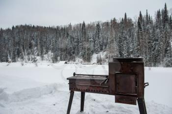 Metal rusty grill in winter forest, relax and resting on the nature concept