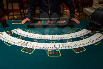 Professional croupier during cards shuffle in the casino