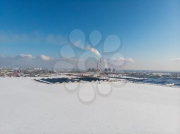 Landscape of smoking chimneys of factories in an industrial city, sunny beauty winter day. Concept of dangerous ecology in city, smoke and smog from factories and plants.