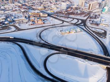 Aerial shot of road and cars driving on the road, winter sunny day in Barnaul, Siberia, Russia