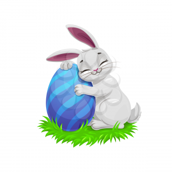 Easter holiday vector bunny or rabbit on easter egg hunt, egghunting party. Gray cartoon bunny on green grass holding a painted egg with blue stripe pattern, Christian religion holiday