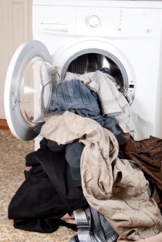 A washing machine and a big pile of laundry