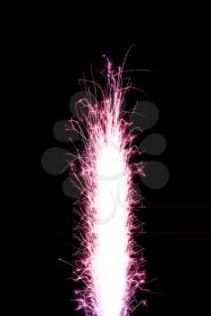 Colored (crimson) birthday fireworks candle over black