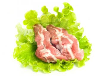 Pieces of Pork meat on green salad. Isolated over white