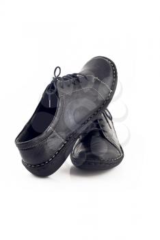 Pair of black leather shoes for women over white background
