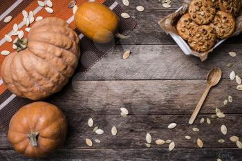 Rustic style pumpkins and cookies with nuts on wood. Autumn Season food photo