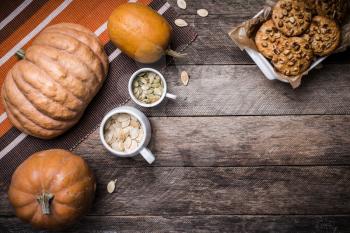Rustic style pumpkins, seeds and cookies with nuts on table. Autumn Season food photo