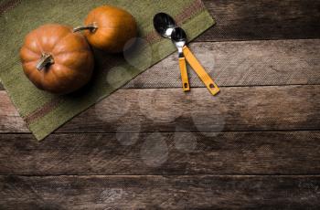 Two pumpkins with spoons on green napkin and wood in Rustic style. Autumn Season food photo