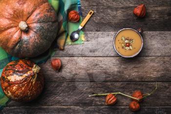 Rustic style Pumpkins and soup with seeds and ground cherry on wooden table. Autumn Season food photo