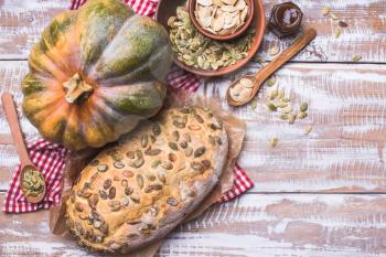 Newly baked bread with pumpkin and seeds wooden table. Rustic style food photo