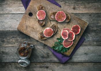 figs, nuts and bread with jam on wooden choppingboard in rustic style. Autumn season food photo