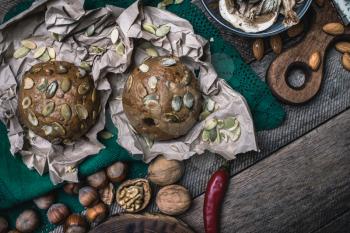 buns with seeds, nuts mushrooms on wooden table  in rustic style
