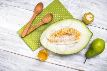 Healthy melon with pear and honey on wooden board in rustic style