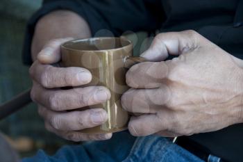 Royalty Free Photo of a Man's Hands Holding a Mug