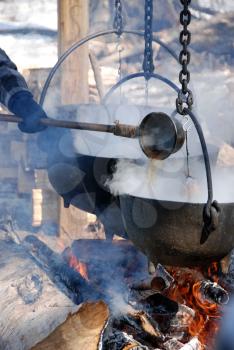 Royalty Free Photo of a Kettle Over an Open Fire
