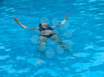Young beautiful woman swimming in the pool