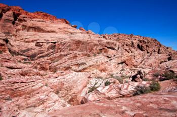 View of dry landscape and red rock formations of the Rde Rock Canyon in the Mojave Desert.