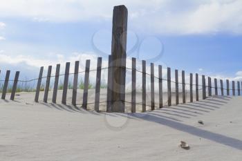 Sand dunes on Atlantic coast with a fence.