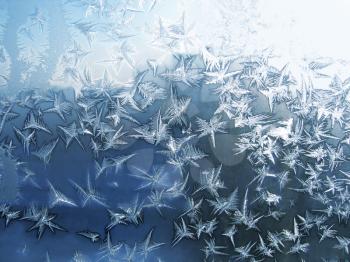 blue frosty natural pattern on winter windowpane