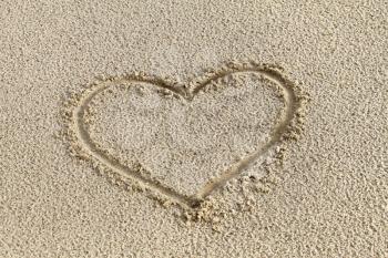 Heart drawing in the sand on the beach 