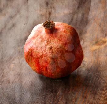 Vintage image with old dry pomegranate on wood background