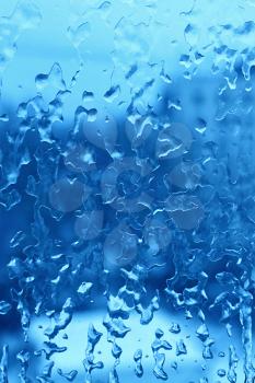 Natural blue texture with frozen water drops on the glass