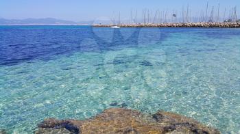 Beautiful sea views with transparent turquoise water, yachts and Palma de Mallorca on the horizon. L'Arenal, Majorca, Balearic Islands, Spain.