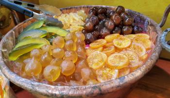 Appetizing candied fruit on a large platter, close-up