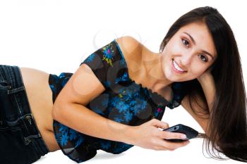 Royalty Free Photo of a Young Girl Lying on the Floor Texting on her Mobile Phone