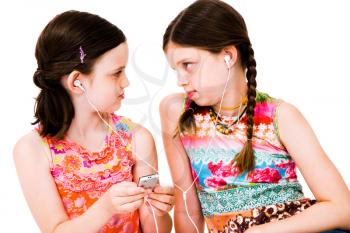 Royalty Free Photo of a Two Young Girls Listening to and Mp3 Player Sharing Earbuds