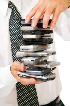 Close-up of a businessman holding a stack of phones isolated over white