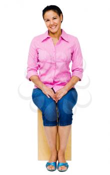 Mixed race woman sitting on a stool and smiling isolated over white