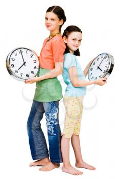 Girls holding clocks and smiling isolated over white