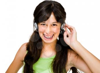 Confident teenage girl wearing headphones and listening to music isolated over white