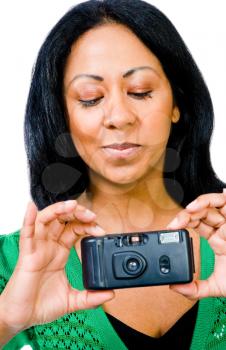 Close-up of a woman photographing with a camera and smiling isolated over white