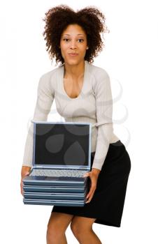 Woman holding a stack of laptops and smiling isolated over white