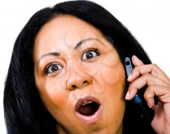 Surprised woman talking on a mobile phone isolated over white