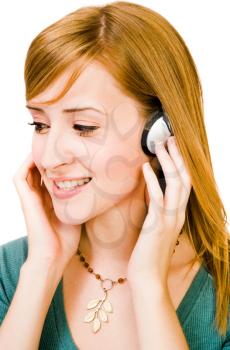 Caucasian woman wearing headphones and listening to music isolated over white