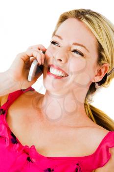 Woman talking on a mobile phone and smiling isolated over white