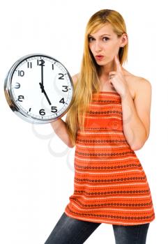 Young woman holding a clock and thinking isolated over white