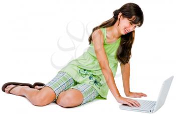Teenager using a laptop and smiling isolated over white