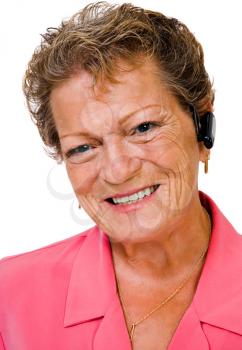 Caucasian woman wearing a bluetooth and smiling isolated over white