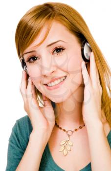 Fashion model wearing headphones and listening to music isolated over white