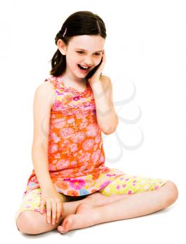 Happy girl talking on a mobile phone isolated over white