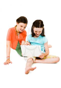 Happy girls using a laptop isolated over white