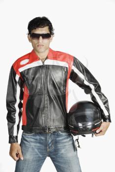 Man wearing sunglasses and holding a crash helmet