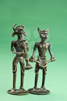 Close-up of two figurines depicting tribal people with animal head