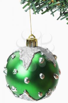 Green bauble hanging on a Christmas tree